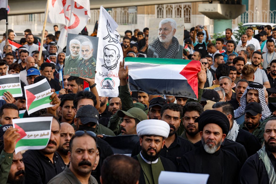 People hold a Palestinian flags as supporters of Iraqi Shi'ite armed groups gather during a protest against the U.S. for supporting Israel, and in support of Palestinians in Gaza, in Najaf, Iraq