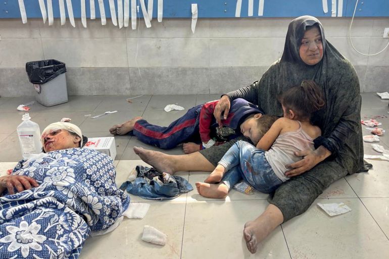 Palestinian woman holds her children, who were wounded along with her in an Israeli strike, at Shifa hospital in Gaza City