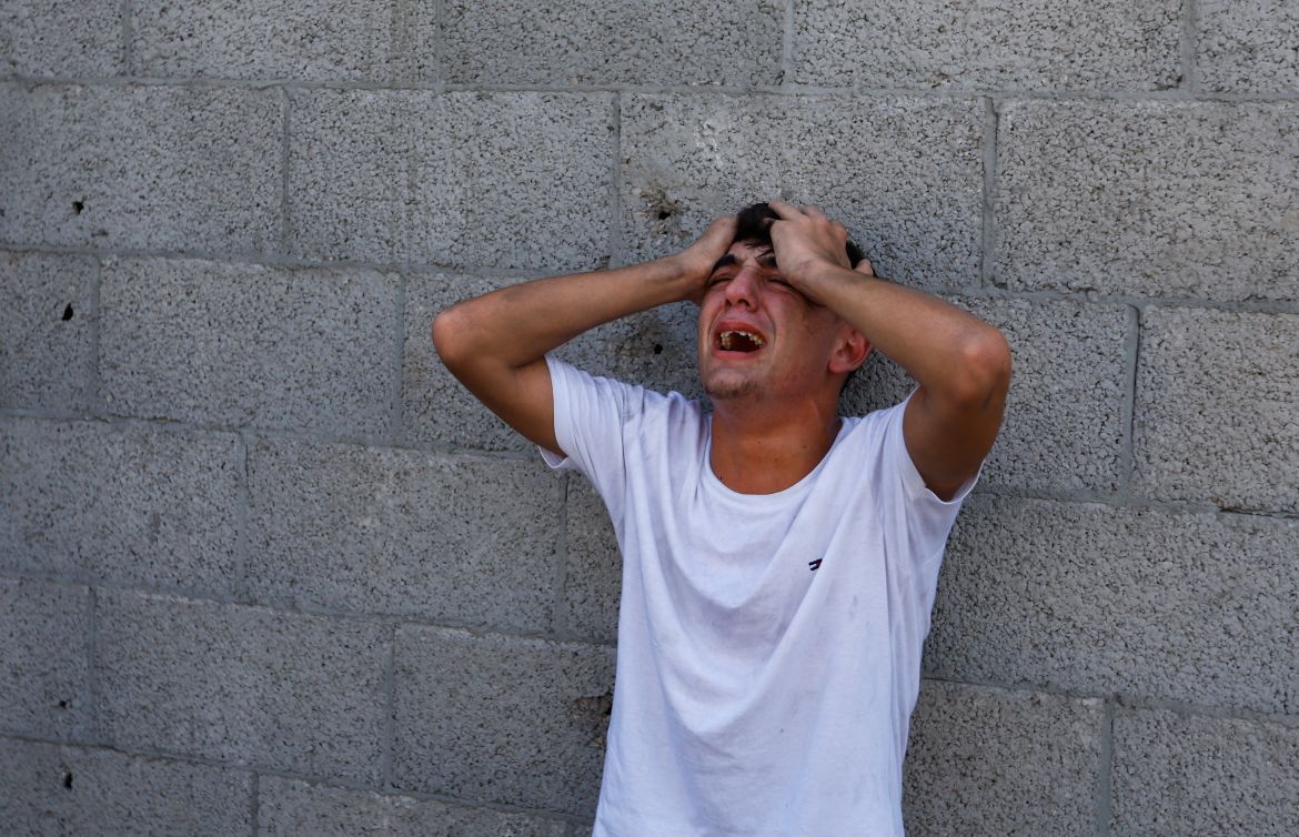 A Palestinian man reacts during a search for casualties following an Israeli strike on a house, in Khan Younis