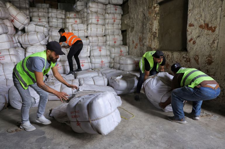 Men move supplies as people take part in an aid campaign leaving from Beirut to southern Lebanon