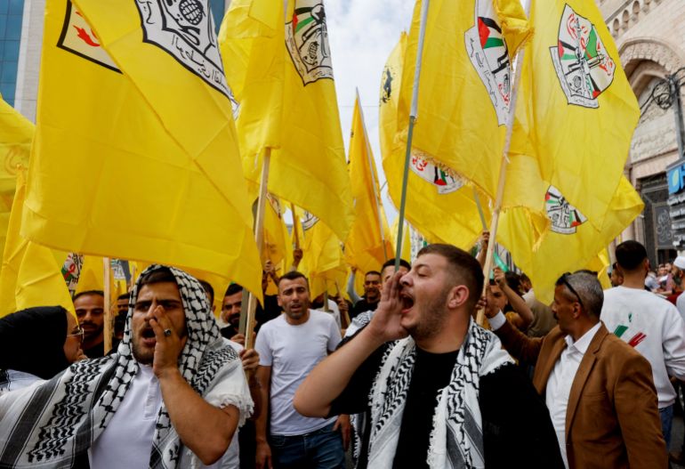 People hold Fatah flags during a protest in support of the people of Gaza