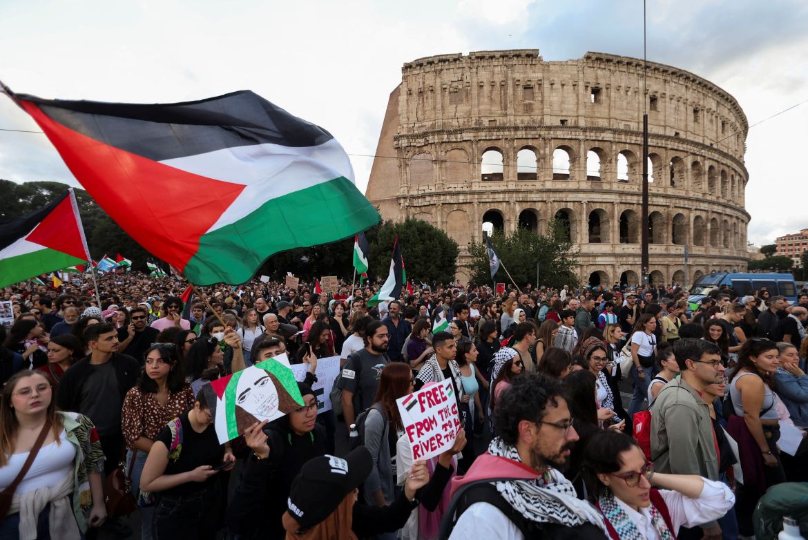People hold Palestinian flags in front of the Colosseum during a demonstration in support of Palestinians in Gaza