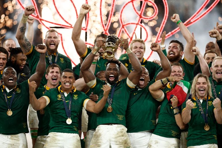 South Africa's Siya Kolisi lifts The Webb Ellis Cup surrounded by cheering teammates