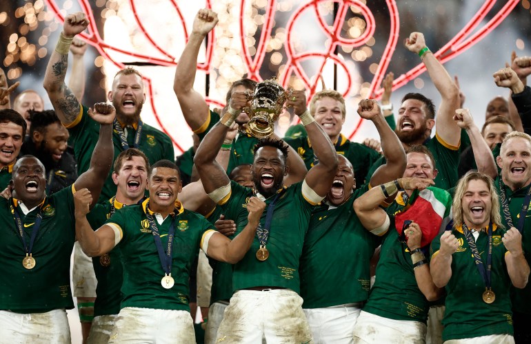 South Africa's Siya Kolisi lifts The Webb Ellis Cup surrounded by cheering teammates