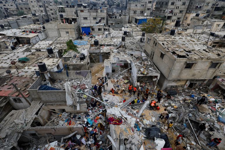 Il personale di emergenza e le persone controllano i danni sul luogo degli attacchi israeliani alle case, nel mezzo del conflitto in corso tra Israele e il gruppo islamico palestinese Hamas, a Khan Younis, nel sud della Striscia di Gaza