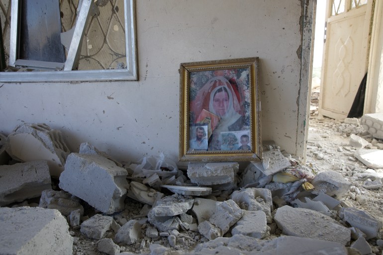 A family portrait lies on the floor amid the rubble of a home