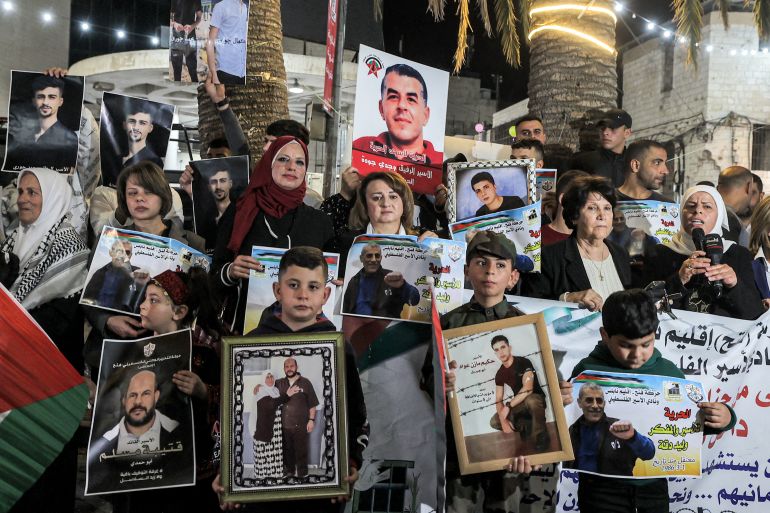 People gather with the pictures of Palestinian prisoners