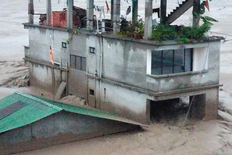 This handout photograph released by the Indian Army and taken on October 4, 2023, shows a house amid flood waters after the Teesta River overflowed in India's Sikkim state following a flash flood caused by intense rainfall. - The Indian army said October 4 that 23 soldiers were missing after a powerful flash flood caused by intense rainfall tore through a valley in the mountainous northeast Sikkim state. (Photo by INDIAN ARMY / AFP) / RESTRICTED TO EDITORIAL USE - MANDATORY CREDIT "AFP PHOTO / INDIAN ARMY - NO MARKETING NO ADVERTISING CAMPAIGNS - DISTRIBUTED AS A SERVICE TO CLIENTS - RESTRICTED TO EDITORIAL USE - MANDATORY CREDIT "AFP PHOTO / Indian Army - NO MARKETING NO ADVERTISING CAMPAIGNS - DISTRIBUTED AS A SERVICE TO CLIENTS /