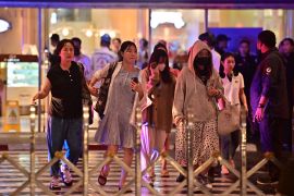 People rush to leave the Siam Paragon shopping mall in Bangkok on October 3, 2023, following a shooting incident [Lillian Suwanrumpha/AFP]