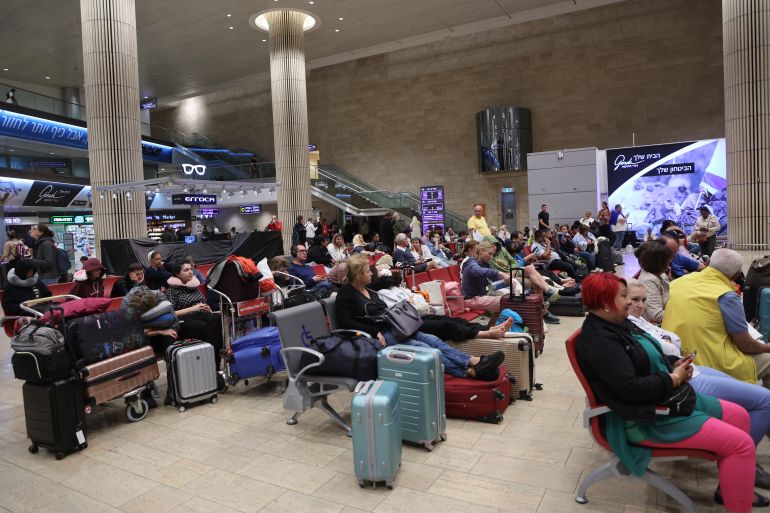 Passengers wait at Ben Gurion Airport near Tel Aviv, Israel, on October 7, 2023, as flights are canceled because of the Hamas surprise attack. The conflict sparked major disruption at Tel Aviv airport, with American Airlines, Emirates, Lufthansa and Ryanair among carriers with cancelled flights. (Photo by GIL COHEN-MAGEN / AFP)