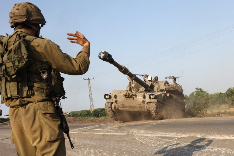 An Israeli soldier directs a self-propelled howitzer near the southern city of Ashkelon on October 8, 2023. Surging violence between Israel and Hamas has killed almost 1,000 people since the Palestinian militants launched a massive surprise attack, officials said Sunday, as Prime Minister Benjamin Netanyahu warned of a "long and difficult" war ahead. (Photo by GIL COHEN-MAGEN/ AFP)