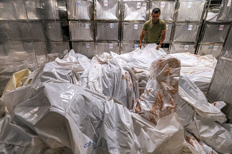A morgue worker arranges body bags at al-Shifa hospital in Gaza City