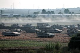 Israeli troops in tanks and other armoured vehicles amass in a field near the Israeli city of Ashkelon on October 14, 2023 [AFP/Thomas Coex]