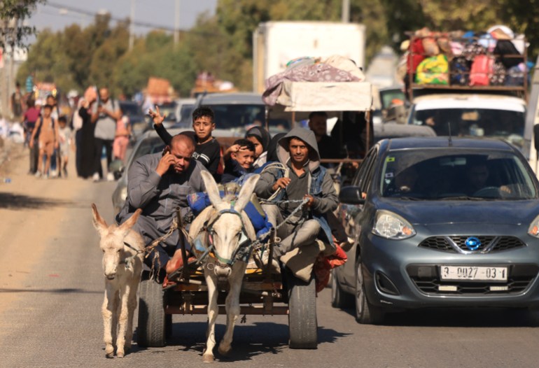 Aboard a donkey cart, a family and hundreds of other Palestinians carrying their belongings flee following Israeli army warning to leave their homes and move south ahead of an expected ground offensive , in Gaza City.