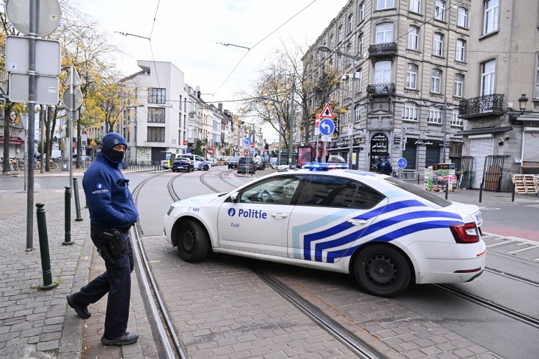 A police car is parked near the house in the Schaerbeek area of Brussels