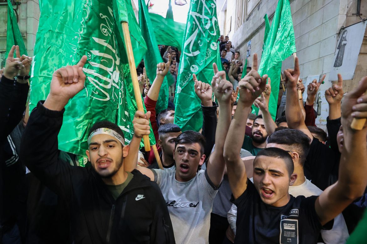 Palestinians lift Hamas movement flags as they protest in Nablus city in the occupied West Bank