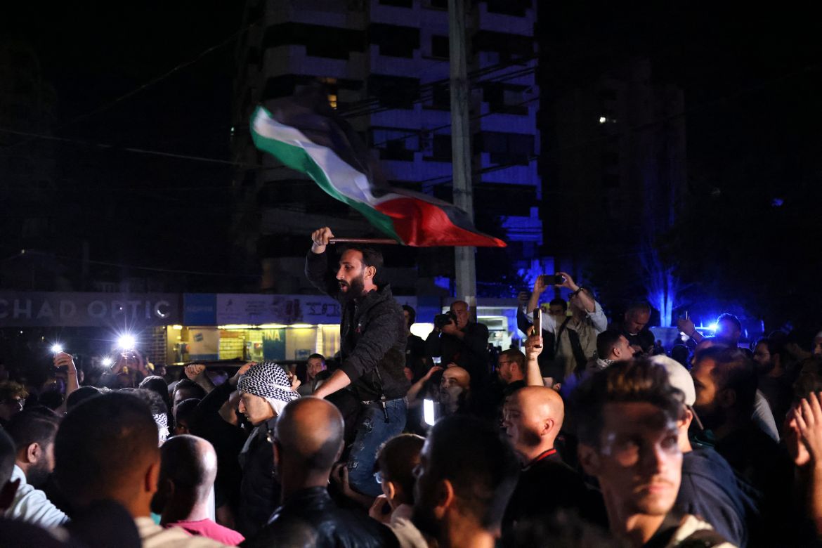 Lebanese protesters wave Palestinian national flags and shout slogans in solidarity with the people of Gaza outside the US Embassy in Awkar