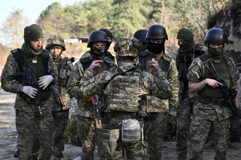 Members of the newly-formed Siberian Battalion in training near Kyiv. They are in a group listening to a commander.