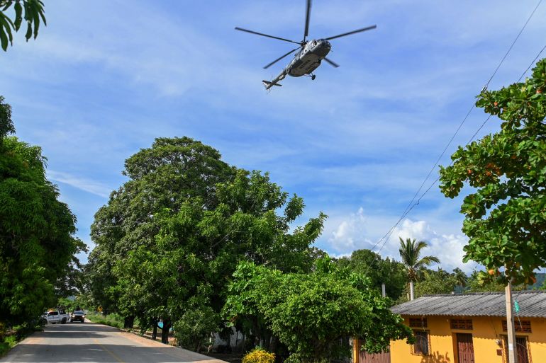 A police helicopter files over the area where police officers were killed in an ambush by criminal groups in Coyuca de Benitez, state of Guerrero, Mexico
