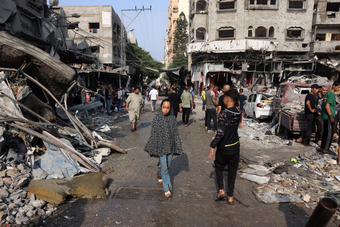 A young girl walks amid the destruction following Israeli strikes on Al-Shatee camp in Gaza City
