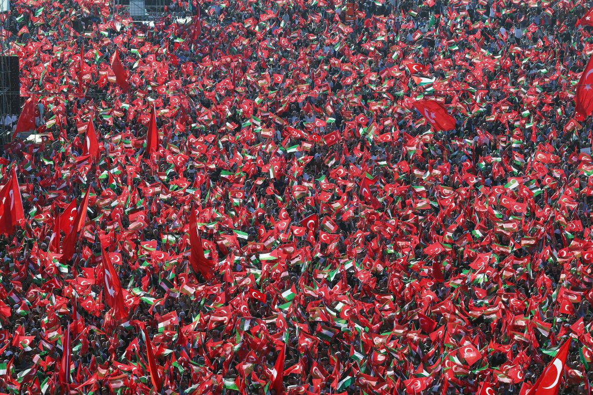 People wave Turkish and Palestinian flags as Turkish President speaks during a rally organised by the AKP party in solidarity with the Palestinians in Gaza