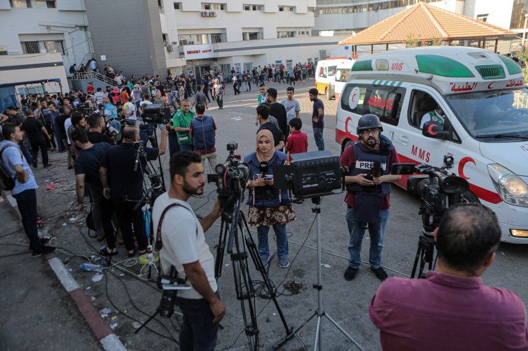 Journalists set up their lives and pieces to camera at the Shifa Hospital grounds in Gaza City, getting information about the different areas Israel targeted from the wounded