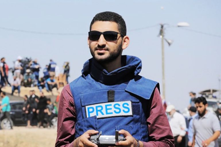 a man in a blue vest that says PRESS