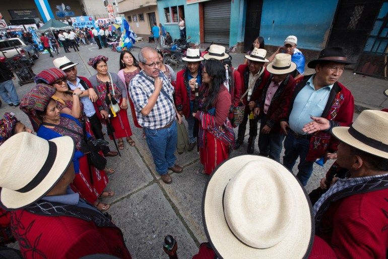 Indigenous leaders gather in a circle around a man speaking as protests unfold in Guatemala in October 2023.