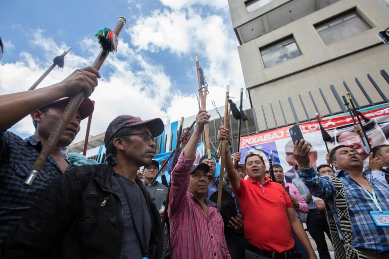 Indigenous protesters raise ceremonial staffs as they rally in Guatemala City