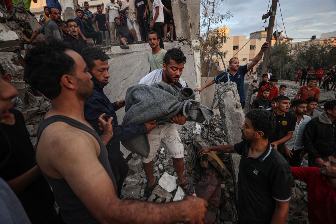 Civil defense members and residents conduct search and rescue operation amid rubble and destroyed buildings after Israeli attacks continue on the 11th day in Khan Yunis