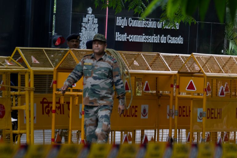 An Indian paramilitary soldier stands guard next to a police barricade outside the Canadian High Commission in New Delhi, India