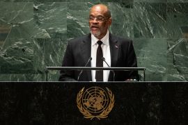 Haitian Prime Minister Ariel Henry stands behind a UN podium, speaking.