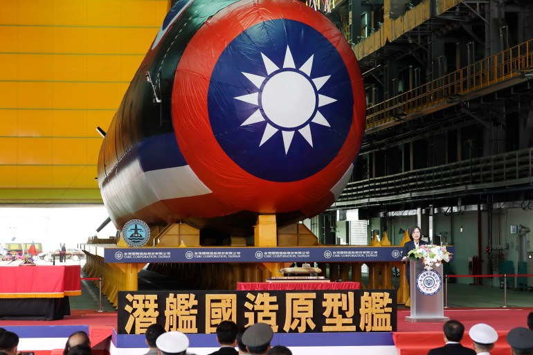 Taiwan President Tsai Ing-wen officiates the launch of the territory's first domestically produced submarine. She is standing at a lectern next to the submarine