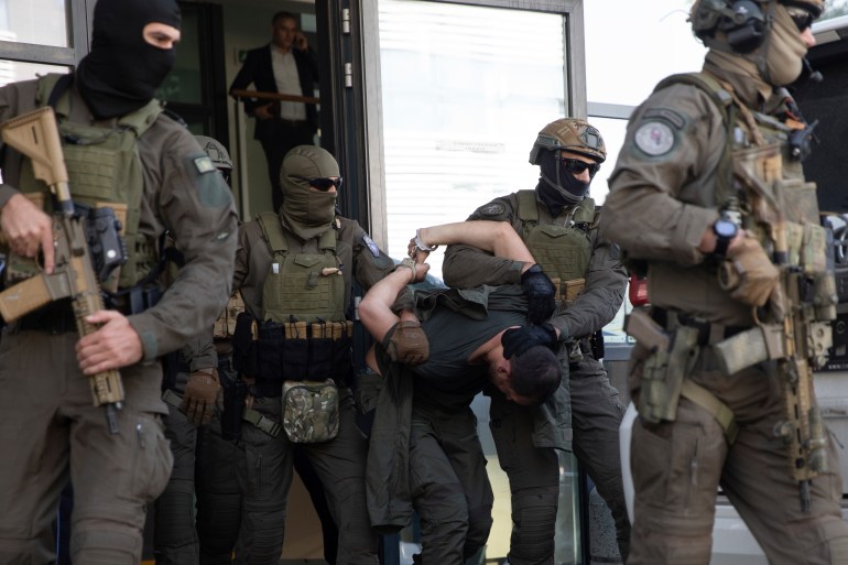 Kosovo police members of Special Intervention Unit escort one of the arrested Serb gunmen out of the court after the Kosovo shootout in capital Pristina.