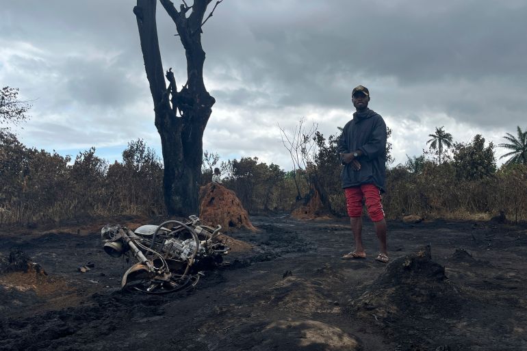 A man stands at the site of an illegal refinery explosion in Emohua, Niger Delta Nigeria Tuesday, Oct. 3, 2023.