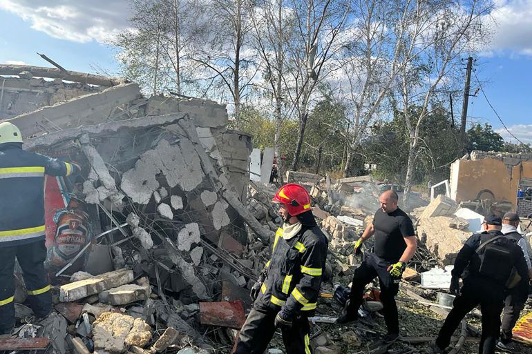 Emergency workers search the victims of the deadly Russian rocket attack that killed more than people in the village of Hroza near Kharkiv, Ukraine