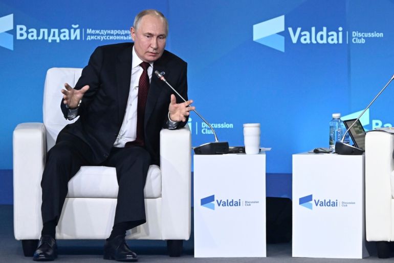 Putin gestures while delivering remarks