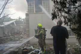Israeli firefighters extinguish a fire after a rocket from the Gaza Strip hit a house in Ashkelon, southern Israel. [Tsafrir Abayov/AP Photo]