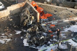 Israeli firefighters extinguish fire after a rocket fired from the Gaza Strip hit a parking lot in Ashkelon, southern Israel [Tsafrir Abayov/AP Photo]
