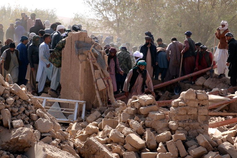 Afghan men search for victims after an earthquake in Zenda Jan district in Herat province, of western Afghanistan