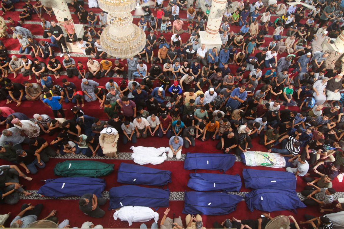 Mourners pray by the bodies of Salem Abu Quta family members, a Hamas fighter, during a funeral after they were killed in an Israeli strike on their house in Rafah refugee camp, southern Gaza Strip
