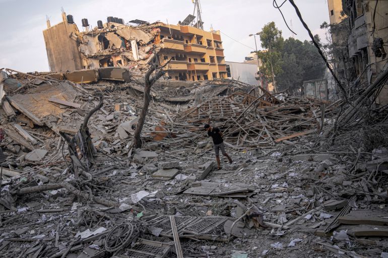 Palestinians inspect the rubble of a building after it was struck by an Israeli airstrike, in Gaza City