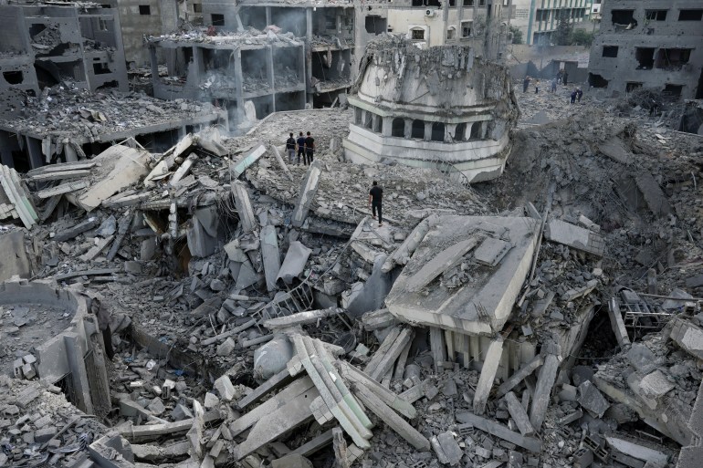 Palestinians inspect the rubble of the Yassin Mosque destroyed after it was hit by an Israeli airstrike at Shati refugee camp in Gaza City, early Monday, Oct. 9, 2023. Israel's military battled to drive Hamas fighters out of southern towns and seal its borders Monday as it pounded the Gaza Strip. (AP Photo/Adel Hana)