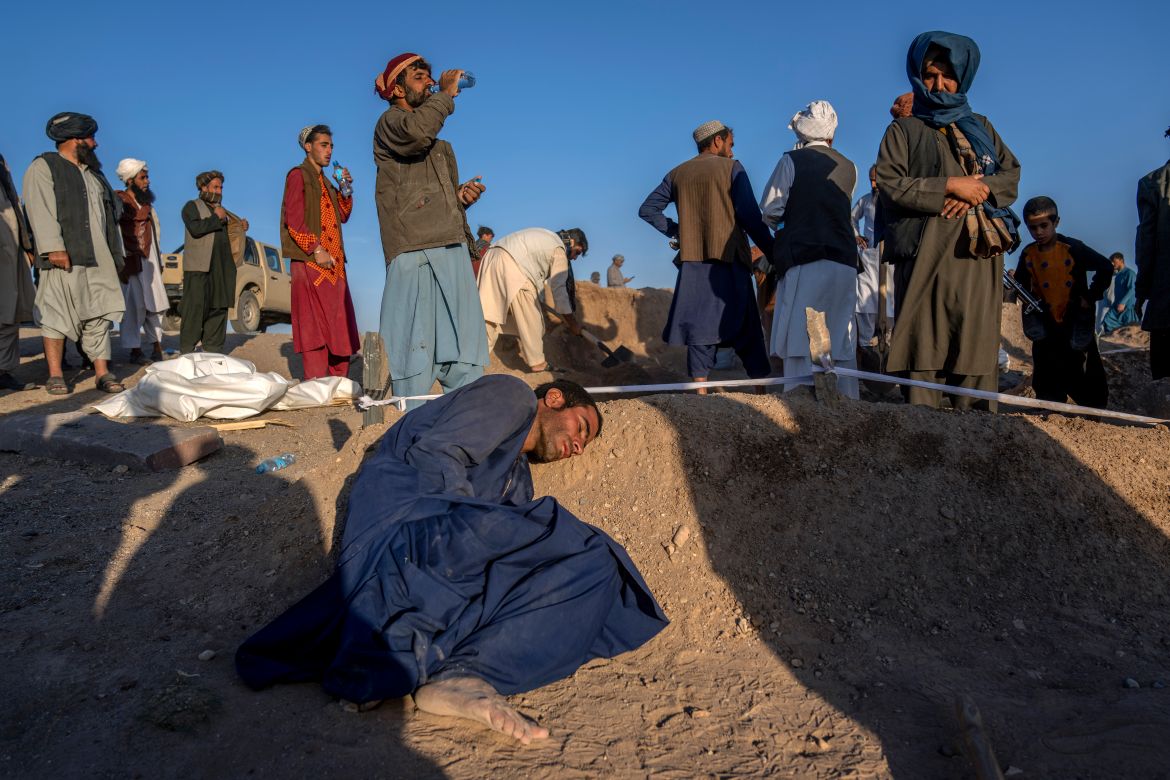 An Afghan man rests his head on the grave of his wife who died due to an earthquake and talks to her at a burial site, in Zenda Jan district in Herat province, western of Afghanistan, Monday, Oct. 9, 2023. Saturday's deadly earthquake killed and injured thousands when it leveled an untold number of homes in Herat province. (AP Photo/Ebrahim Noroozi)