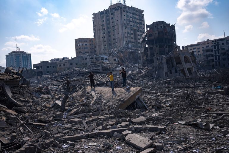 Palestinians inspect the rubble of buildings hit by an Israeli airstrike, in Gaza City