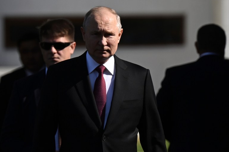 Vladimir Putin walking and looking stern.