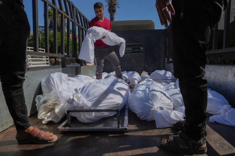 Sheet-covered bodies killed during an Israeli airstrike are loaded onto a truck