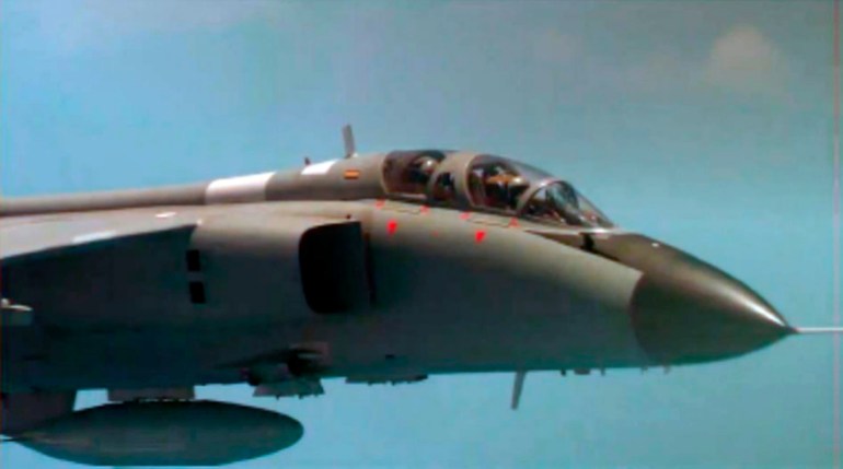 A Chinese fighter jet pictured from a US military aircraft. The cockpit crew are clearly visible.