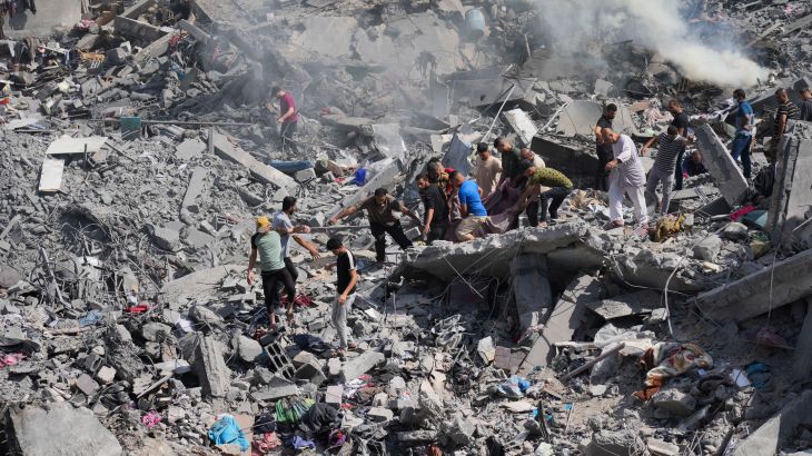 Palestinians pull dead from the building destroyed in an Israeli airstrike in Bureij refugee camp Gaza Strip