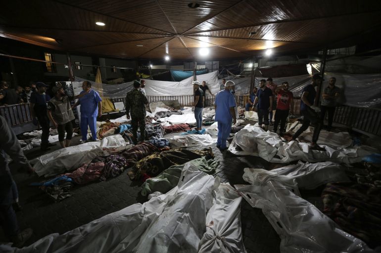 I corpi dei palestinesi uccisi all'ospedale Ahli Arab sono raccolti nel cortile dell'ospedale al-Shifa, a Gaza City